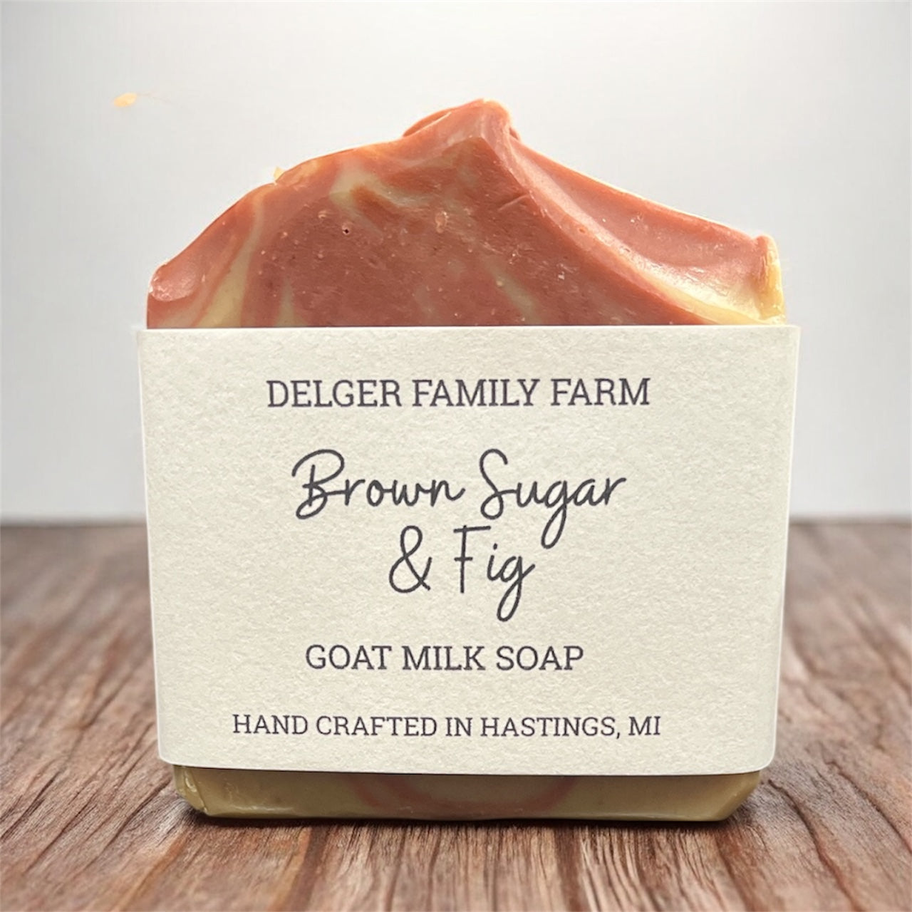 Bar of soap with a label on a wooden surface, featuring ‘Delger Family Farm' branding.