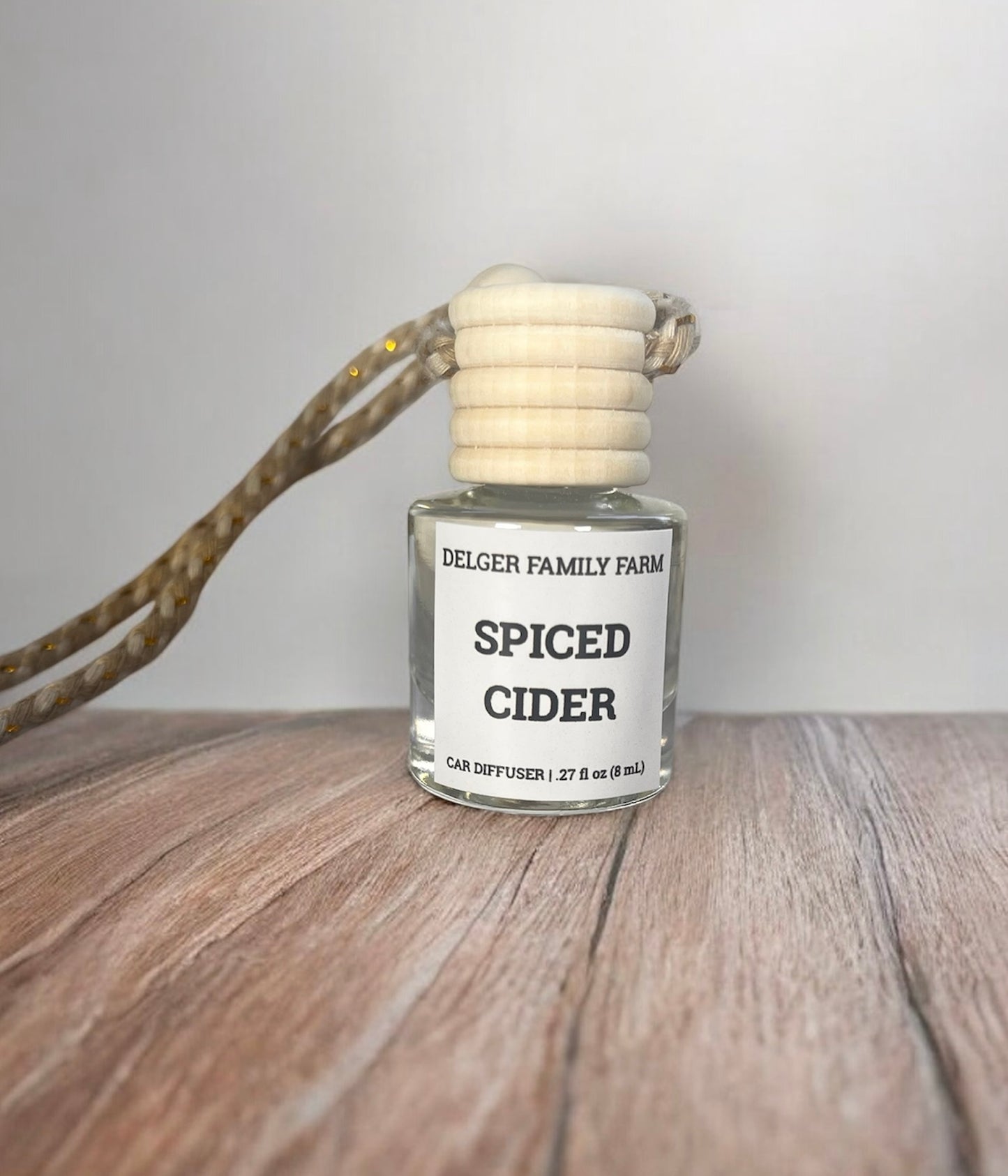 Spiced Cider car diffuser on a wooden surface with a neutral background