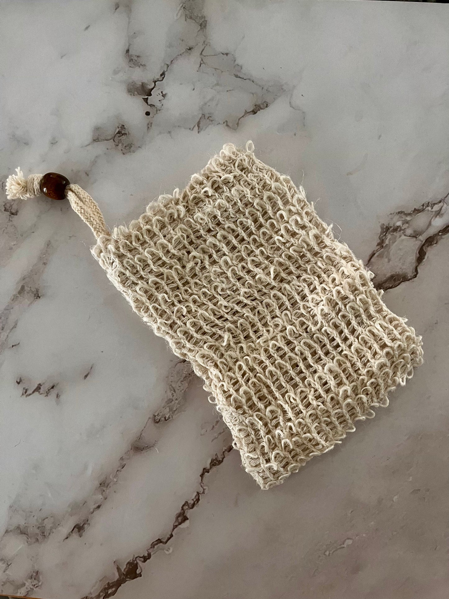 cream knitted bag on marble surface