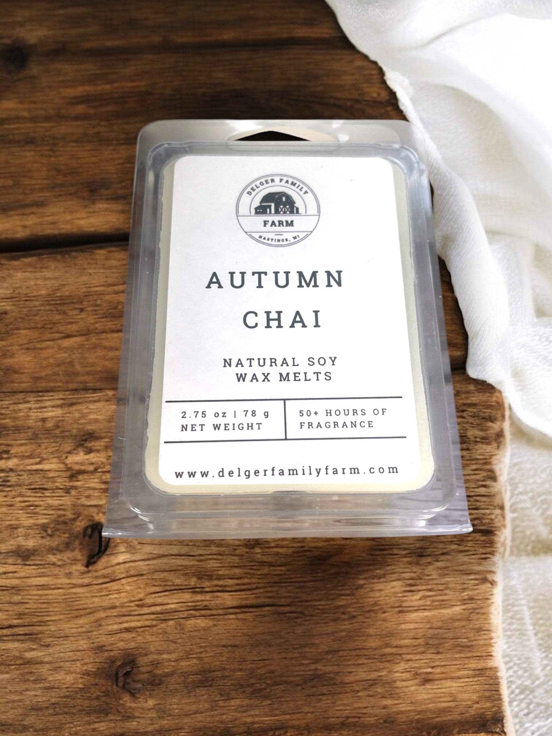 Pack of 'Autumn Chai' natural soy wax melts on a wooden surface with a white cloth.
