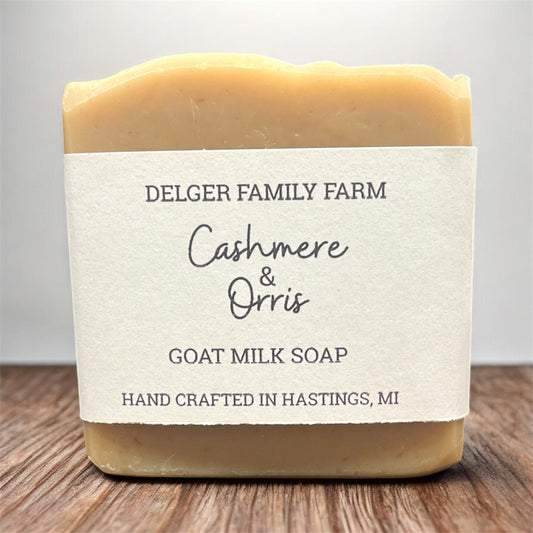 Bar of goat milk soap from Delger Family Farm on a wooden surface with a white background