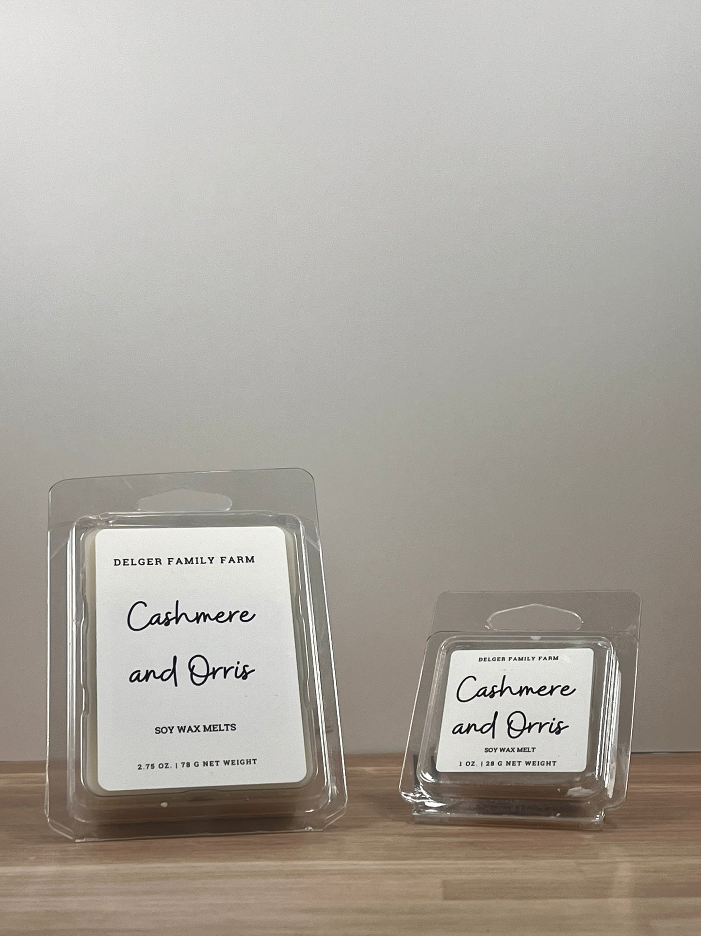 Small and large wax melt container sitting on wood. 