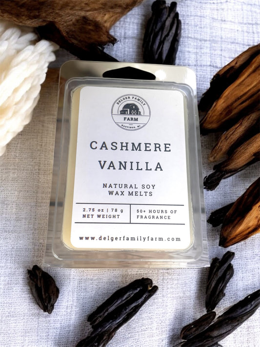 Cashmere Vanilla wax melt packaging with dried vanilla beans on a textured surface