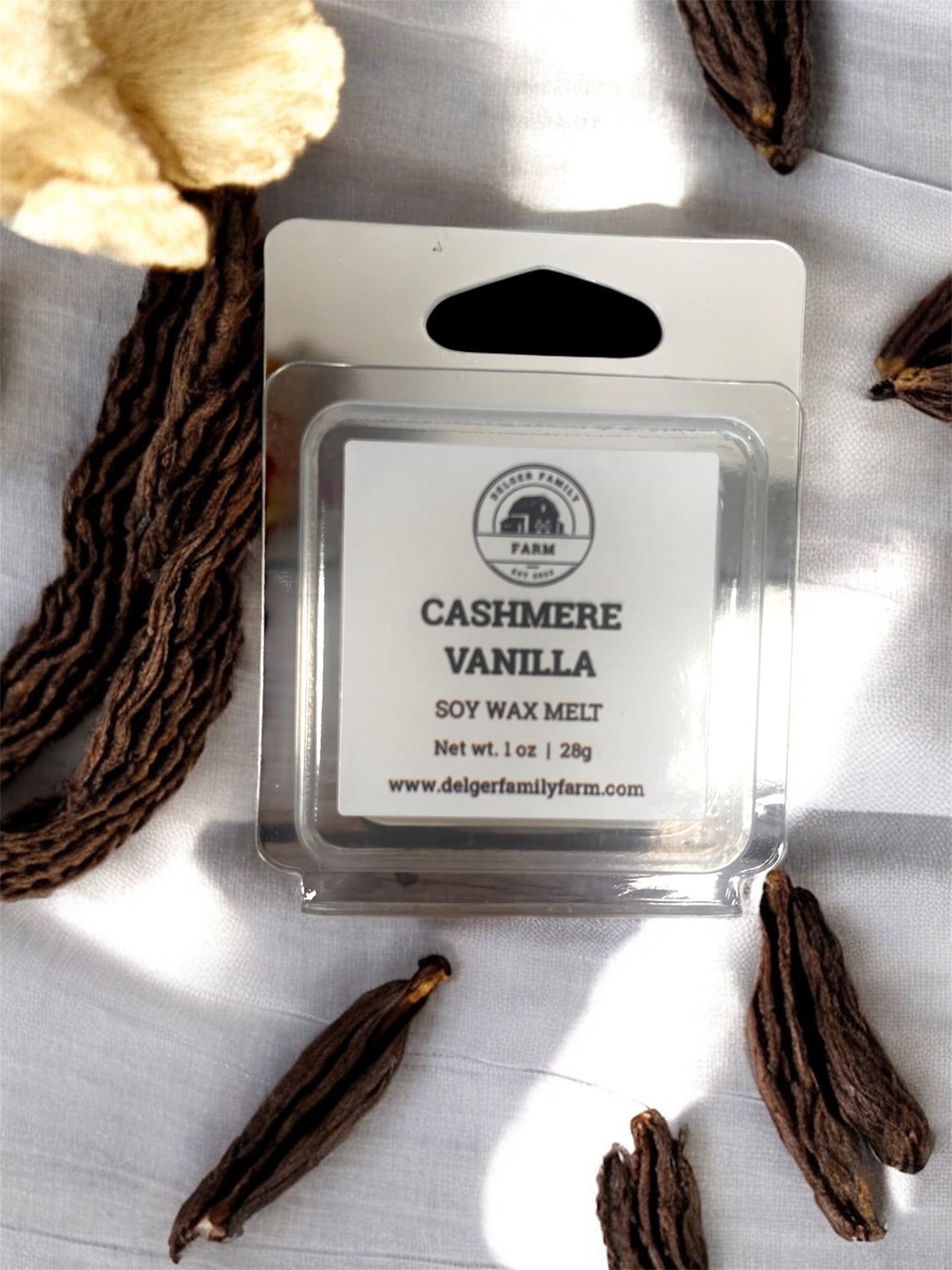 Cashmere Vanilla soy wax melt packaging with vanilla beans on a light background