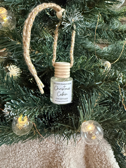 Small bottle ornament labeled 'Christmas Cabin' on a decorated Christmas tree.