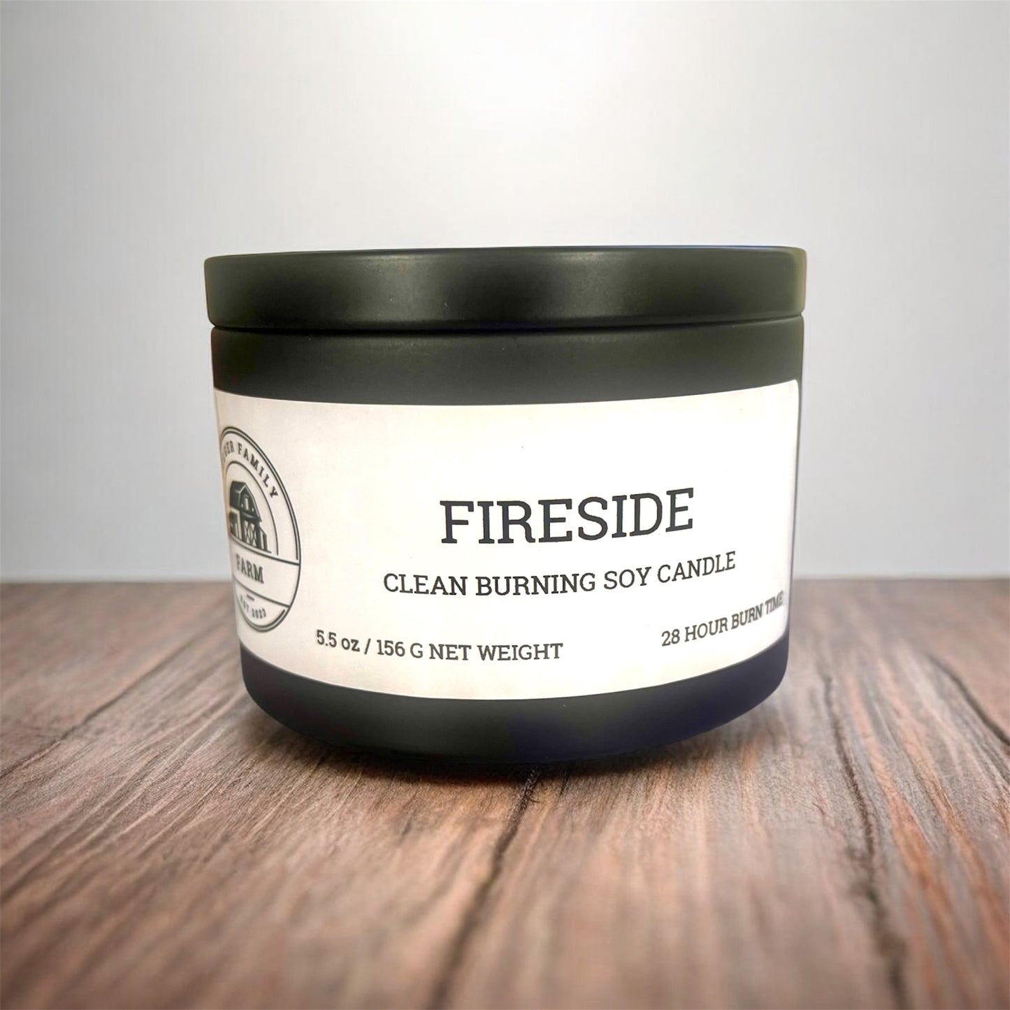 Fireside candle with a black lid on a wooden surface