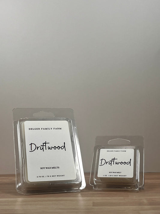Small and large wax melt container sitting on wood. 