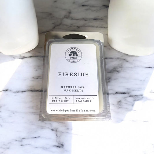 Pack of Delger Family Farm Fireside wax melts on a marble surface with two wax melts in the background.