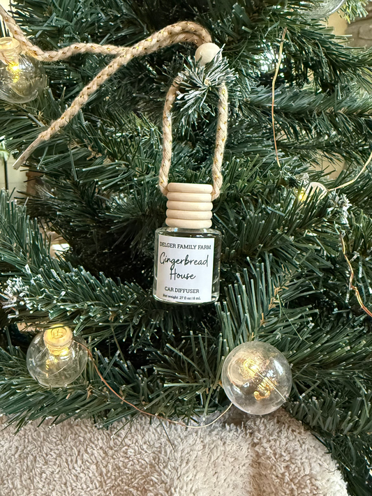 Small bottle labeled 'gingerbread house' on a Christmas tree with decorative lights.
