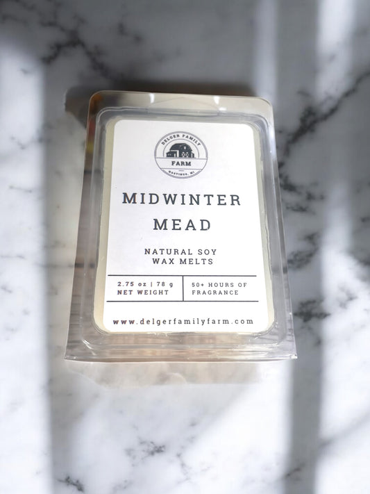 Pack of Delger Family Farm Midwinter Mead wax melts on a marble surface