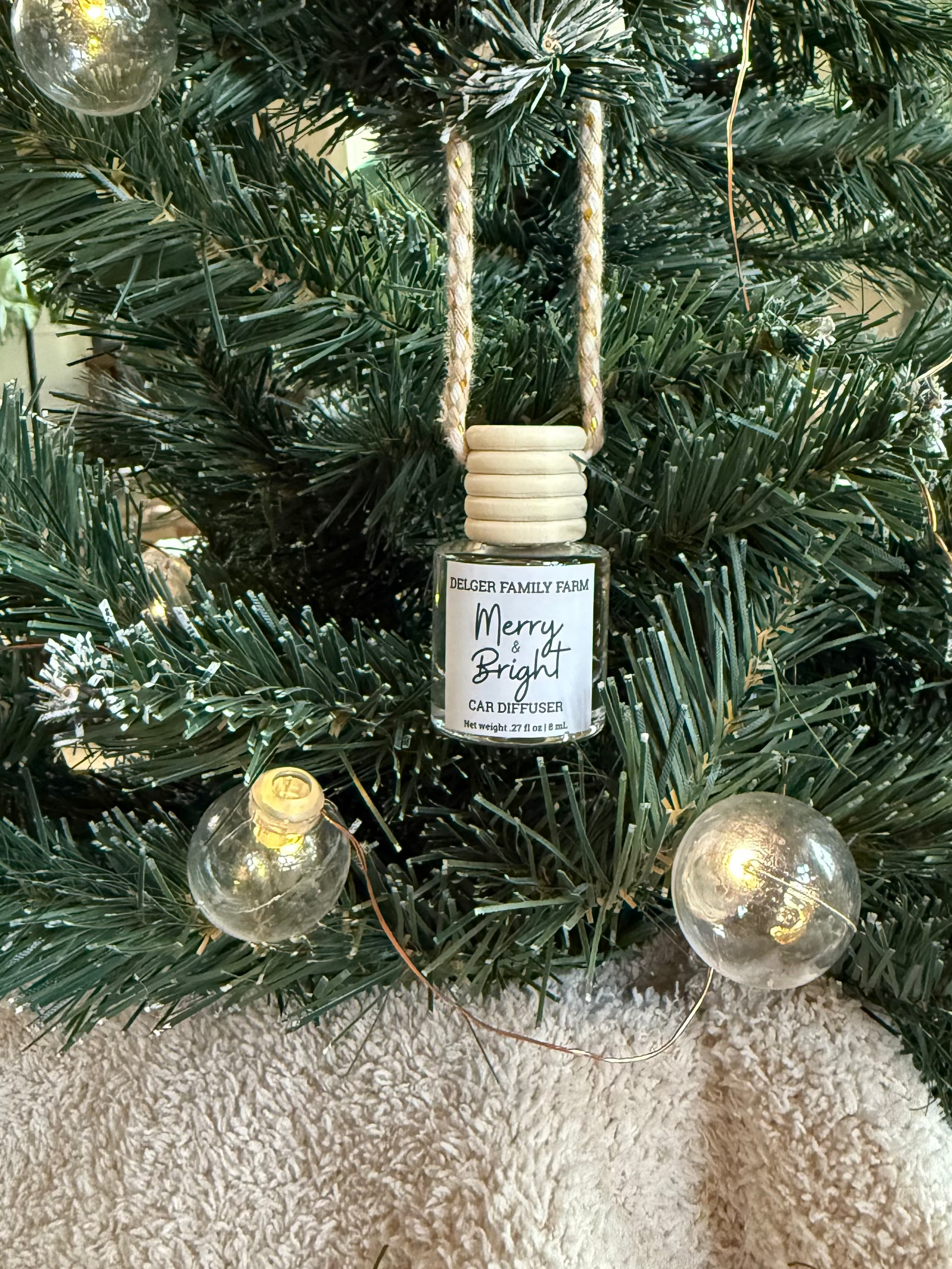 Decorative ornament with a small bottle labeled 'Merry & Bright' on a Christmas tree.