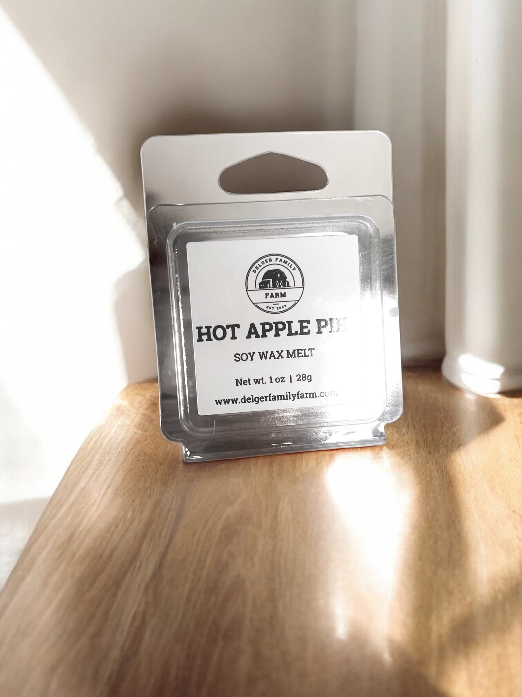 Soy wax melt package labeled 'Hot Apple Pie' on a wooden surface with a white background.