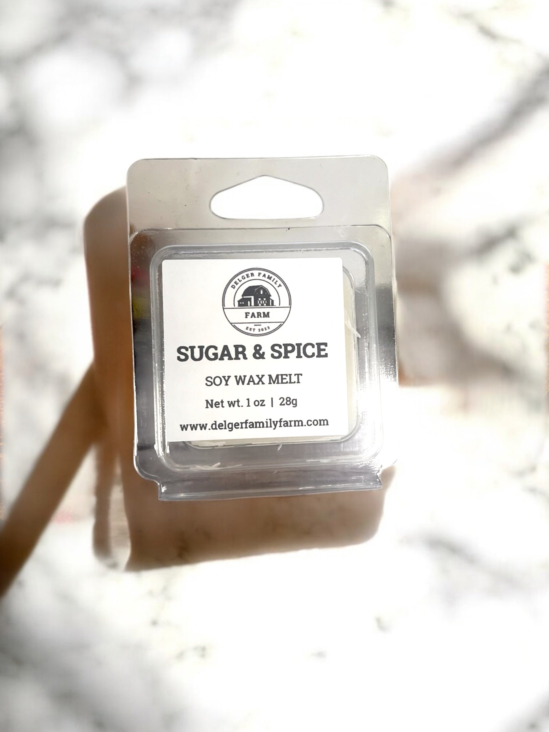 Soy wax melt package labeled 'Sugar & Spice' by Delger Family Farm on a light background.
