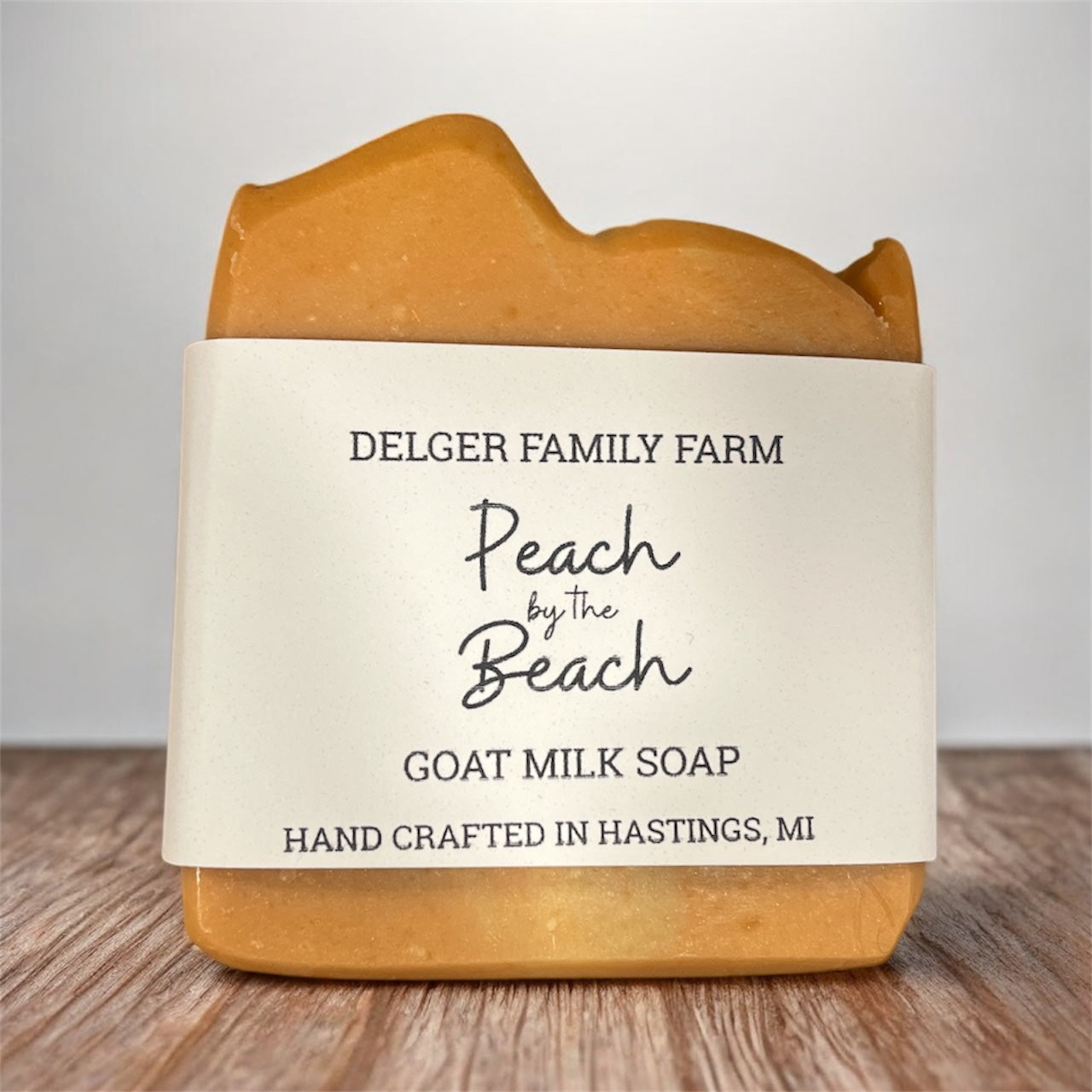 Light orange Bar of soap with a label on a wooden surface