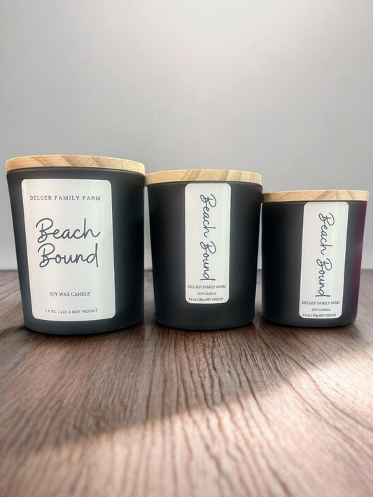 Three candles with labels on a wooden surface