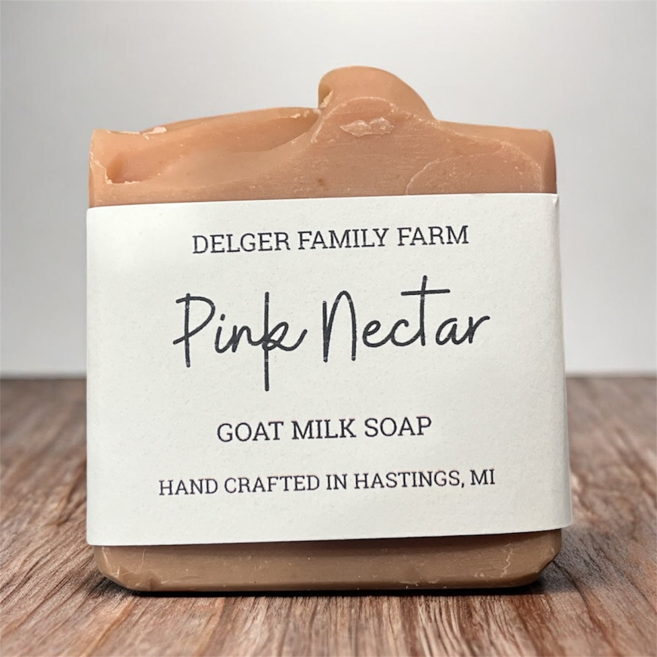 Goat milk soap bar from Delger Family Farm with a white label on a wooden surface.