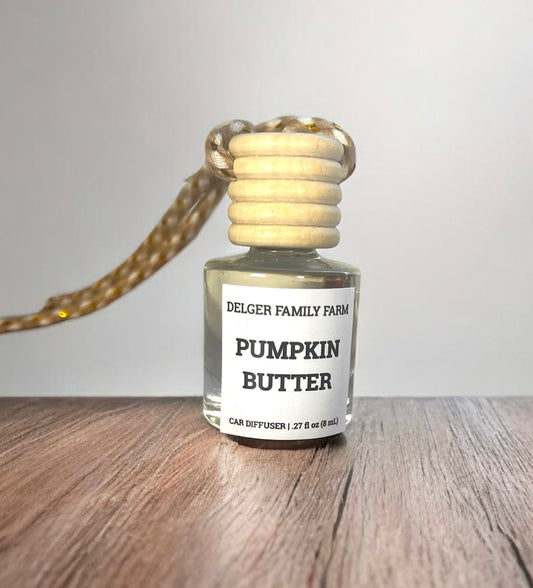 Small bottle labeled 'Pumpkin Butter' by Delger Family Farm on a wooden surface with a neutral background.