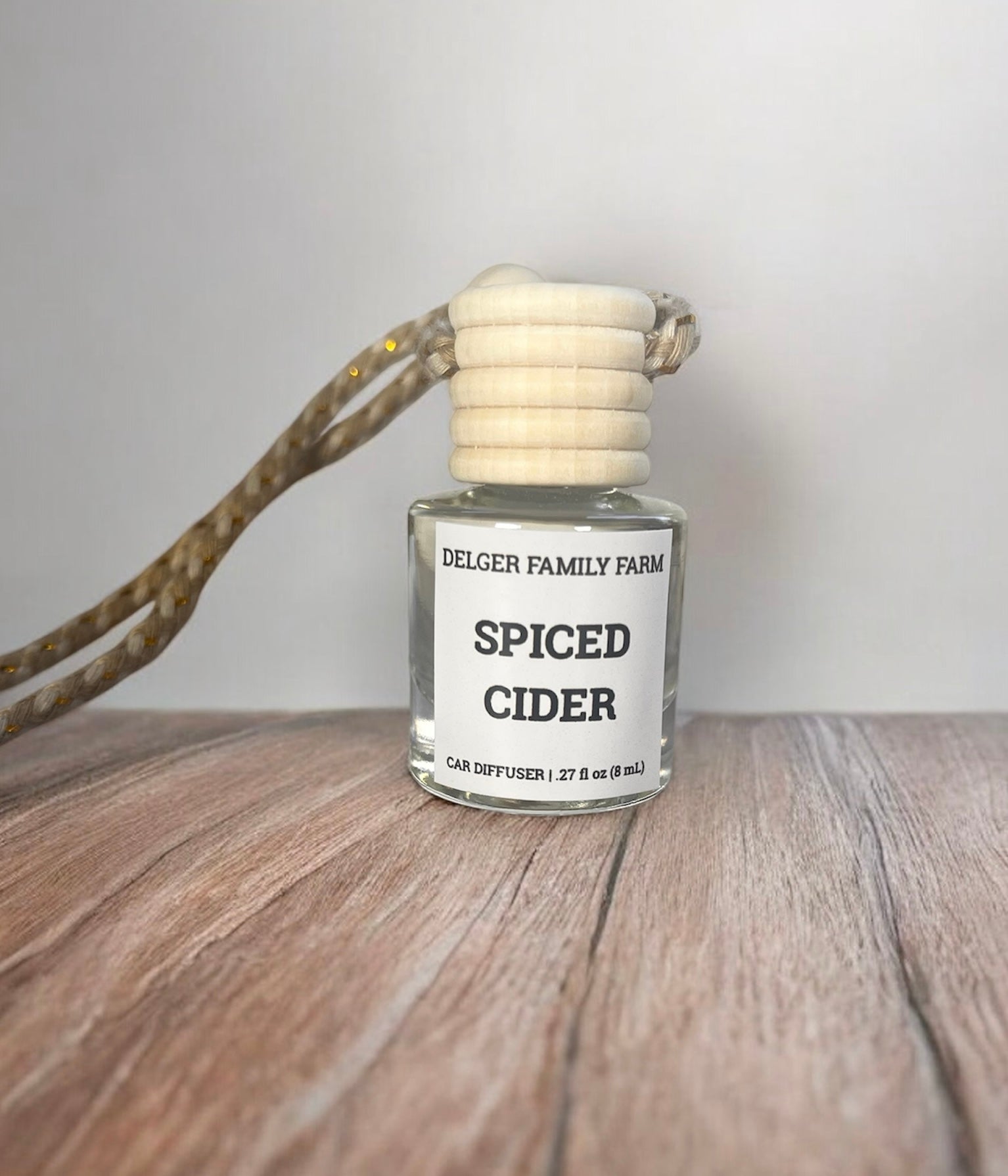 Spiced Cider car diffuser on a wooden surface with a neutral background