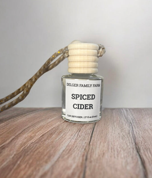 Spiced Cider car diffuser on a wooden surface with a neutral background