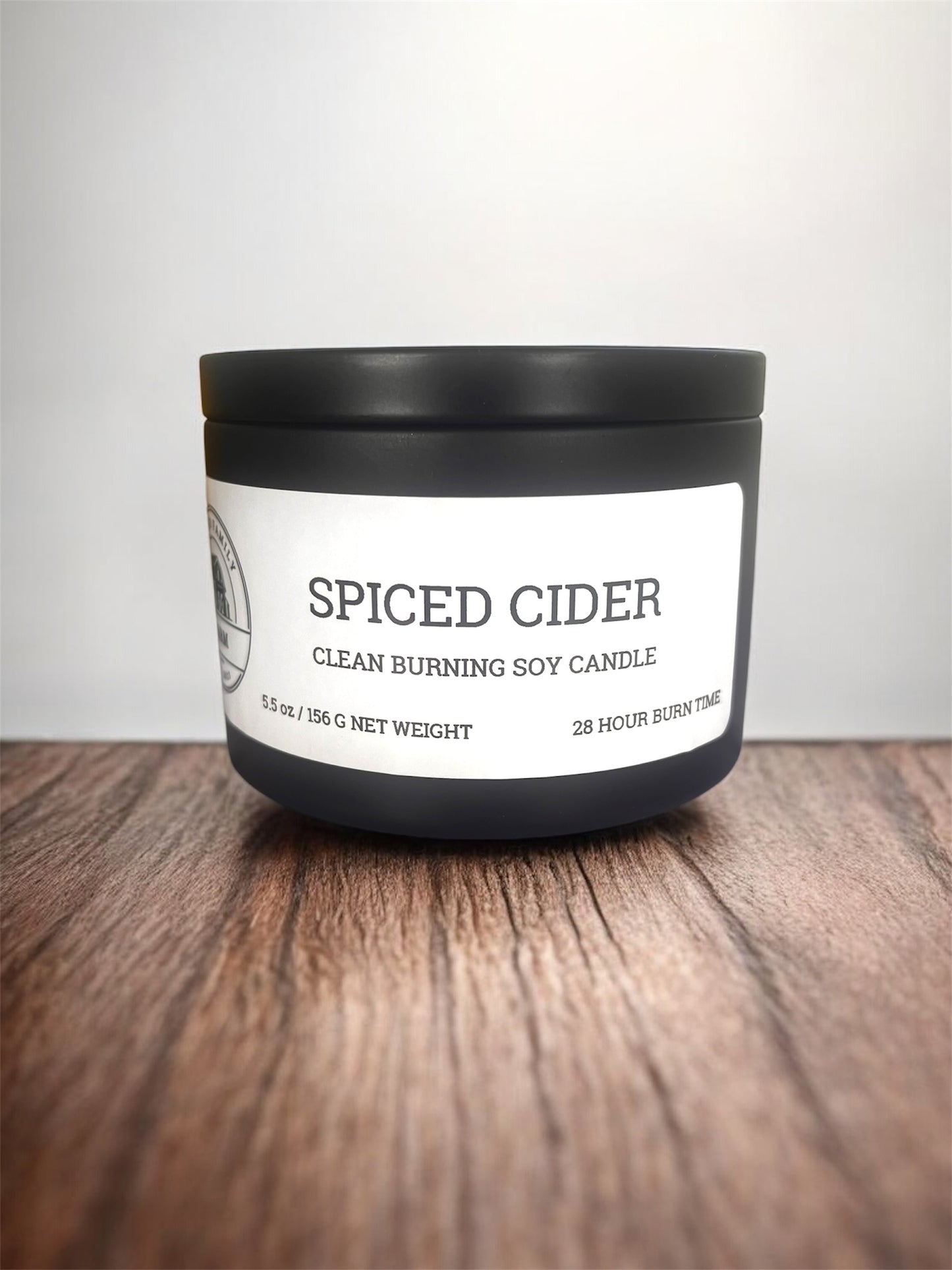 Spiced Cider candle with black lid on a wooden surface