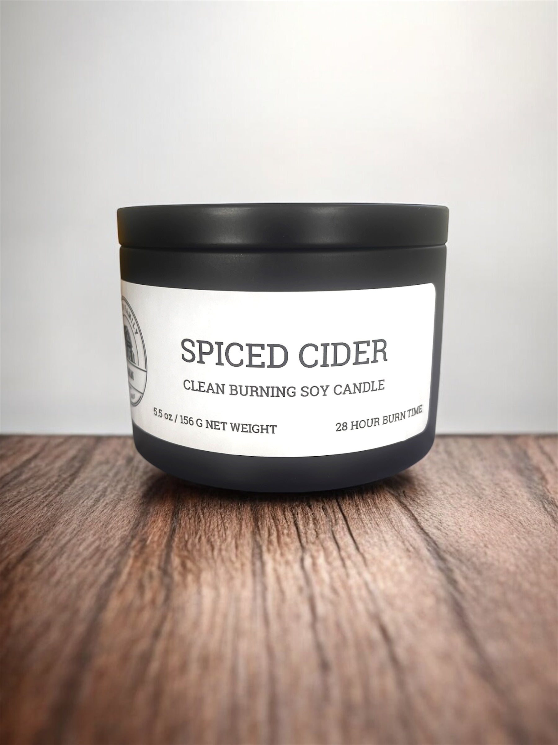 Spiced Cider candle with black lid on a wooden surface