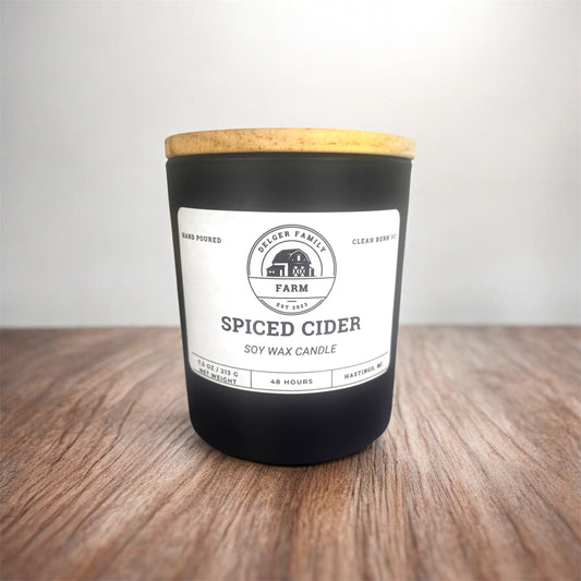 Spiced Cider candle with a wooden lid on a wooden surface