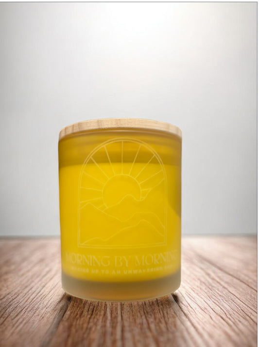 Yellow candle with a wooden lid on a wooden surface