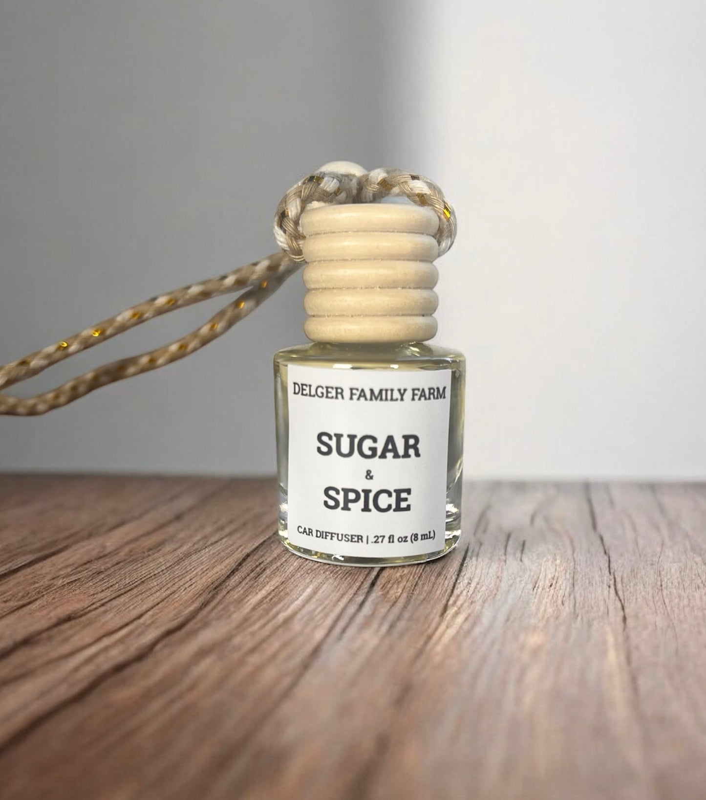 Diffuser bottle labeled 'Sugar & Spice' by Delger Family Farm on a wooden surface.