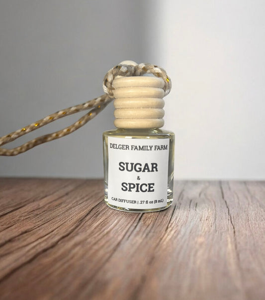 Diffuser bottle labeled 'Sugar & Spice' by Delger Family Farm on a wooden surface.