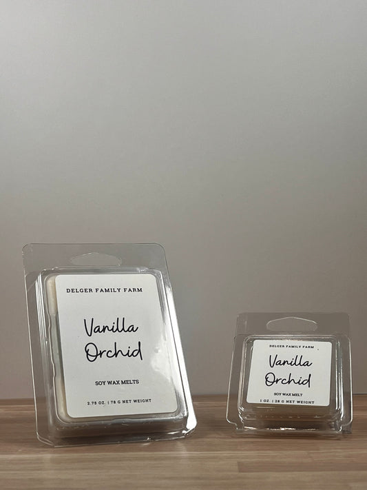 Small and large wax melt container sitting on wood. 